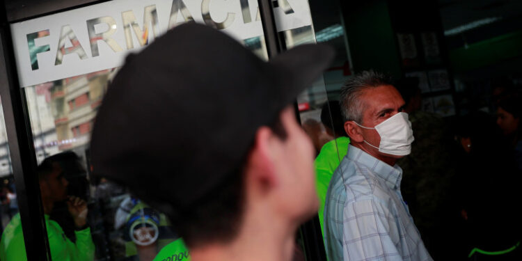 A man wears a protective mask  outside the pharmacy in response to coronavirus (COVID-19) spread in Caracas, Venezuela March 13, 2020. REUTERS/Carlos Jasso