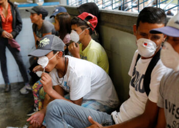 People outside a metro station wear face masks distributed by members of the Taiwan and Venezuela Parliamentary Friendship team, in response to the spreading coronavirus (COVID-19), in Caracas, Venezuela March 12, 2020. REUTERS/Carlos Jasso