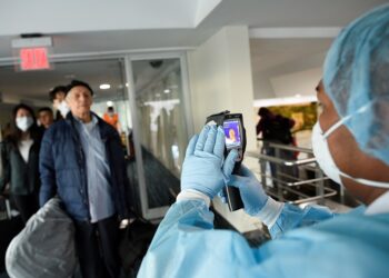 A worker from Ecuador's Health Ministry uses a thermal scanner to check passengers arriving from the U.S., as part of the security measures due to the outbreak of the coronavirus (COVID-19), at Jose Joaquin de Olmedo International Airport in Guayaquil, Ecuador March 13, 2020. REUTERS/Santiago Arcos