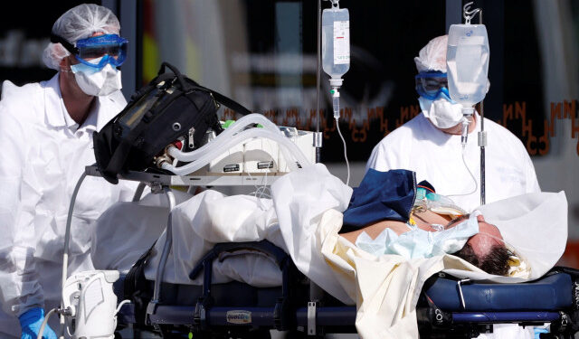 Un equipo de rescate francés con trajes protectores lleva a un paciente al hospital de la Universidad de Estrasburgo. 16 de marzo de 2020. REUTERS/Christian Hartmann
