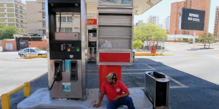 Un trabajador se sienta cerca del surtidor en una estación de servicio vacía después de una orden de cerrarlas en el fronterizo estado Zulia, en un intento de contener la propagación del coronavirus (COVID-19) en Maracaibo, Venezuela Marzo 18, 2020. Foto tomada el 18 de marzo, 2020. REUTERS/Isaac Urrutia