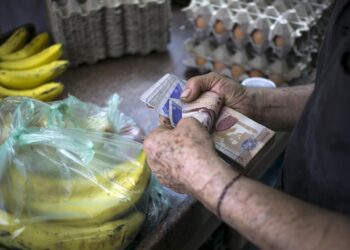 A clerk counts Venezuelan bolivar banknotes after selling goods to a customer at a fruit and vegetable store in Caracas July 10, 2015. A debilitating recession and a drop in oil prices have harmed the OPEC nation's ability to provide dollars through its complex three-tiered currency control system, pushing up the black market rate at a dizzying speed. The bolivar sank past 600 per U.S. dollar on Thursday, compared with 73 a year ago, according to anti-government website DolarToday. REUTERS/Marco Bello