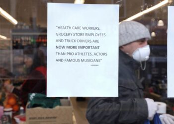 Un letrero pegado en la ventana de una tienda dice que los trabajadores de la salud, los dependientes de tiendas de alimentos y los camioneros son ahora más importantes que los deportistas profesionales y los músicos famosos en Brooklyn, Nueva York. 28 de marzo de 2020. REUTERS/Caitlin Ochs