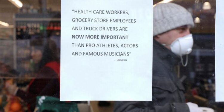 Un letrero pegado en la ventana de una tienda dice que los trabajadores de la salud, los dependientes de tiendas de alimentos y los camioneros son ahora más importantes que los deportistas profesionales y los músicos famosos en Brooklyn, Nueva York. 28 de marzo de 2020. REUTERS/Caitlin Ochs