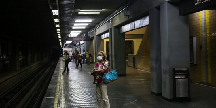 A woman waits for the subway wearing a face mask as a preventive measure in the face of the global COVID-19 coronavirus pandemic, in Caracas, on March 14, 2020. - Venezuela requires a 'mandatory quarantine' for all travelers from Europe who arrived in the country in March, one day after confirming their first two cases of coronavirus. (Photo by Cristian Hernandez / AFP)