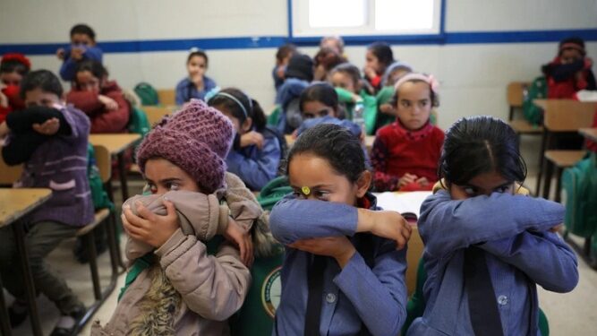 Niños refugiados sirios aprenden la forma correcta de cubrirse para estornudar y toser ante la amenaza de coronavirus.