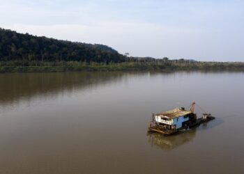 The boat of an illegal gold miner, or "garimpeiro," is seen on a river in the Amazon basin, south of Porto Velho, in the northwestern Brazilian state of Rondonia, on August 27, 2019. (Photo by Carlos FABAL / AFP)