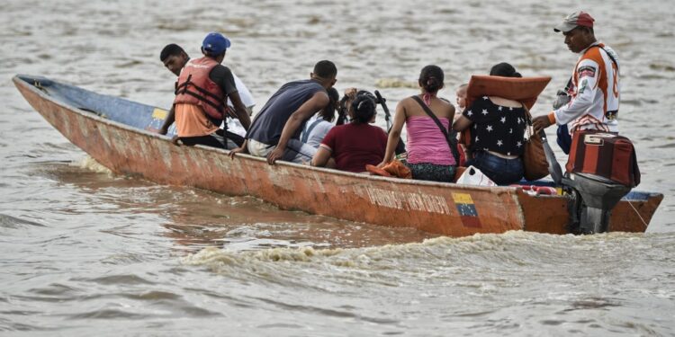 Venezuelans are transported in a canoe in the Arauca River in Arauca, Colombia, on border with Venezuela, on May 15, 2019. - Venezuelan migrants find anti-personnel mines, forced recruitment of armed groups, trafficking networks in Colombia. Vulnerable, the migrants are cannon fodder of all traffics. (Photo by Juan BARRETO / AFP)