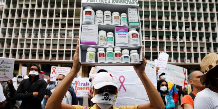 A woman carrying empty medication containers takes part in a protest due to the shortages of medicines outside the Health Ministry in Caracas, Venezuela April 18, 2018. The placard reads, "Shortage in antiretroviral medications". REUTERS/Carlos Garcia Rawlins