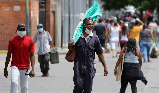 A man walks on the street with his face unprotected during the national quarantine in response to the spread of coronavirus disease (COVID-19) in Caracas, Venezuela, March 21, 2020. REUTERS/Manaure Quintero