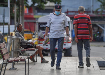 A man wearing a face mask as a precautionary measure against the spread of the new coronavirus, COVID-19, walks in Panama City on March 25, 2020. - Panama's President, Laurentino Cortizo, declared a total quarantine on Tuesday to contain the rapid expansion of the new coronavirus, which registers 443 infections and eight deaths in the Central American country. (Photo by Luis ACOSTA / AFP)