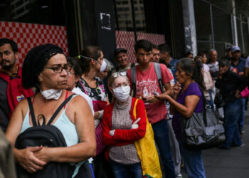 People queue to enter a super market in the face of the global COVID-19 coronavirus pandemic, in Caracas, on March 13, 2020. (Photo by CRISTIAN HERNANDEZ / AFP)