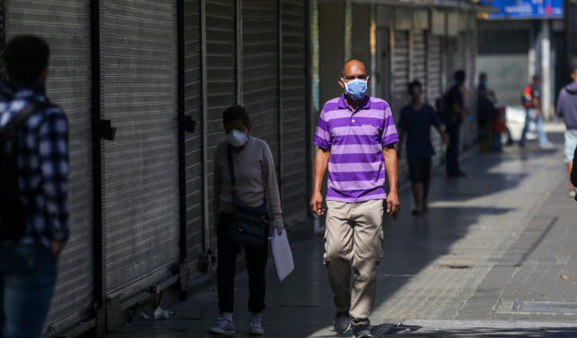 People wear face masks as a precautionary measure against the spread of the new coronavirus, COVID-19, in Caracas, on March 16, 2020. - Venezuelan President Nicolas Maduro ordered on Sunday a "collective quarantine" in seven states, including the capital Caracas, from Monday to stem the spread of the new coronavirus pandemic. (Photo by Cristian Hernandez / AFP)