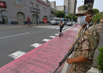Peruvian army soldiers control traffic in Lima on March 16, 2020, in an attempt to persuade the population to stay at home, one day after President Martin Vizcarra announced a State of Emergency and a two-week nationwide home-stay quarantine together with the closure of all borders to fight the spread of the novel COVID-19 coronavirus. - No fatalities have been recorded of the 86 cases of Covid-19 detected in the country. (Photo by Cris BOURONCLE / AFP)