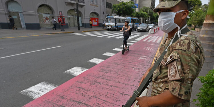 Peruvian army soldiers control traffic in Lima on March 16, 2020, in an attempt to persuade the population to stay at home, one day after President Martin Vizcarra announced a State of Emergency and a two-week nationwide home-stay quarantine together with the closure of all borders to fight the spread of the novel COVID-19 coronavirus. - No fatalities have been recorded of the 86 cases of Covid-19 detected in the country. (Photo by Cris BOURONCLE / AFP)