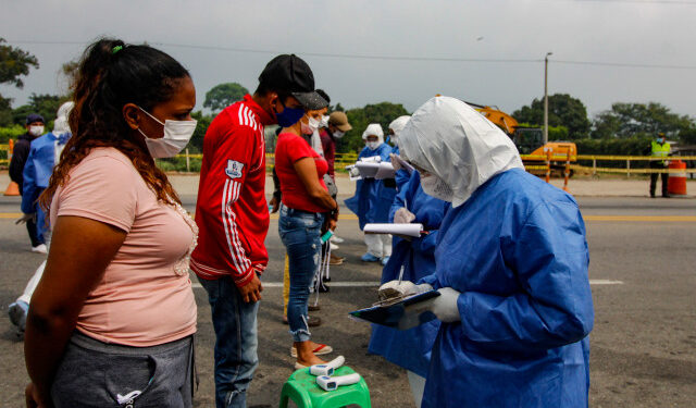 Staffers from the Secretary of Health check Venezuelans while returning to the country from Colombia, as a preventive measure against the spread of the coronavirus -COVID19- at the Simon Boliviar International Bridge, in Cucuta, Colombia-Venezuela border, on April 4, 2020. - Since the first case of COVID-19 was detected last March 6, Colombia has reported 1,406 people infected and 32 dead. (Photo by Schneyder MENDOZA / AFP)