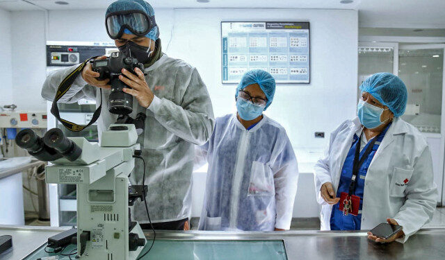 Venezuelan AFP photographer Juan Barreto wears a face mask as he works at the Red cross blood bank in Bogota on April 14, 2020. (Photo by Camila Diaz / AFP)