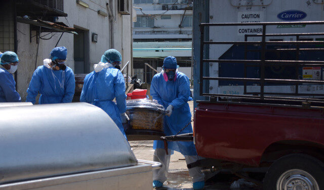Health workers wearing protective gear load a coffin onto the back of a pick-up truck outside of Teodoro Maldonado Carbo Hospital amid the spread of the coronavirus disease (COVID-19), in Guayaquil, Ecuador April 3, 2020. Picture taken April 3, 2020. REUTERS/Vicente Gaibor del Pino NO RESALES. NO ARCHIVES