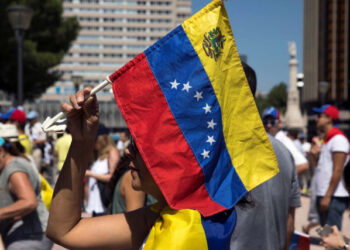 A woman holds a Venezuelan national flag during an unofficial plebiscite against Venezuela's President Nicolas Maduro's government in Madrid, Spain, July 16, 2017. REUTERS/Juan Medina
