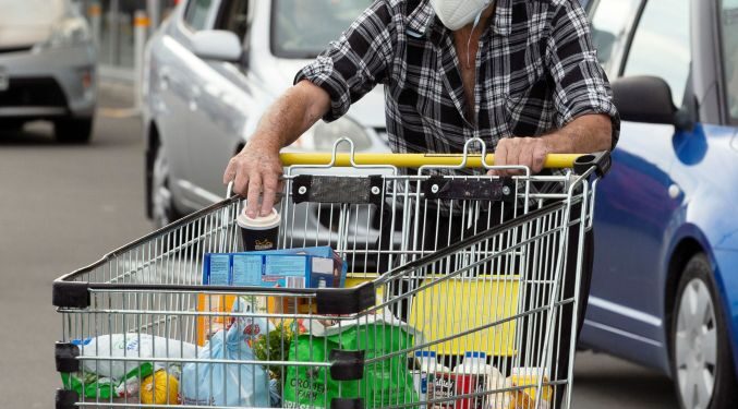 Brian Green, 76, wears a mask as he takes out products from his supermarket shopping cart and load them into his car outside Pak'nSave supermarket amid the spread of the coronavirus disease (COVID-19) in Christchurch, New Zealand, March 23, 2020. REUTERS/Martin Hunter