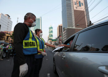 Police officers check the documents of a driver during the curfew as the coronavirus disease (COVID-19) outbreak continues, in Panama City, Panama March 31, 2020. REUTERS/Erick Marciscano