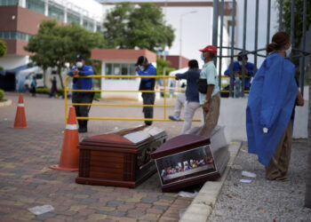 People wait next to coffins outside of Guasmo Sur General Hospital after Ecuador reported new cases of coronavirus disease (COVID-19), in Guayaquil, Ecuador April 1, 2020. REUTERS/Vicente Gaibor del Pino NO RESALES. NO ARCHIVES