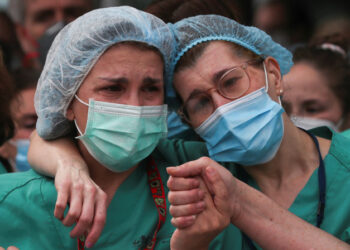Health workers wearing protective face masks react during a tribute for their co-worker Esteban, a male nurse that died of the coronavirus disease, amid the coronavirus disease (COVID-19) outbreak, outside the Severo Ochoa Hospital in Leganes, Spain, April 13, 2020. REUTERS/Susana Vera