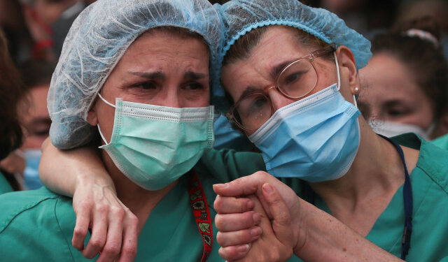 Health workers wearing protective face masks react during a tribute for their co-worker Esteban, a male nurse that died of the coronavirus disease, amid the coronavirus disease (COVID-19) outbreak, outside the Severo Ochoa Hospital in Leganes, Spain, April 13, 2020. REUTERS/Susana Vera