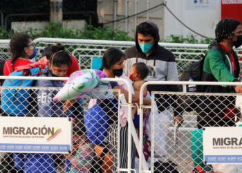 Venezuelan migrants wearing face masks line up at the Simon Bolivar border bridge after travelling on buses assigned by Colombian Migration office for their return to Venezuela, amid the coronavirus disease (COVID-19) outbreak, in Cucuta, Colombia April 15, 2020. REUTERS/Mario Caicedo. NO RESALES. NO ARCHIVES.