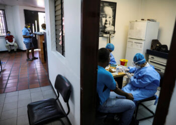 Trabajadores médicos toman muestras de sangre de un hombre para una prueba rápida de la enfermedad por coronavirus (COVID-19), en un centro médico de Caracas, Venezuela. 15 de abril de 2020. REUTERS/Manaure Quintero.