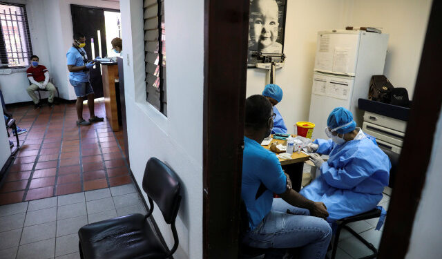 Trabajadores médicos toman muestras de sangre de un hombre para una prueba rápida de la enfermedad por coronavirus (COVID-19), en un centro médico de Caracas, Venezuela. 15 de abril de 2020. REUTERS/Manaure Quintero.