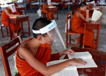 Monjes budistas novatos que usan protectores faciales y mascarillas asisten a una lección en el instituto educativo monástico Wat Molilokayaram, en Bangkok, Tailandia. 22 de abril de 2020. REUTERS/Soe Zeya Tun.
