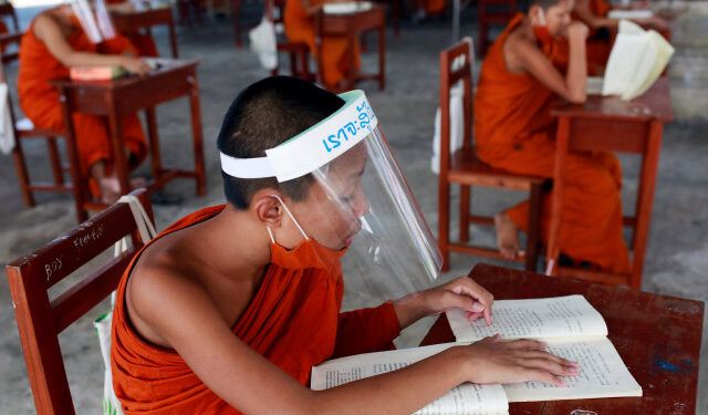 Monjes budistas novatos que usan protectores faciales y mascarillas asisten a una lección en el instituto educativo monástico Wat Molilokayaram, en Bangkok, Tailandia. 22 de abril de 2020. REUTERS/Soe Zeya Tun.