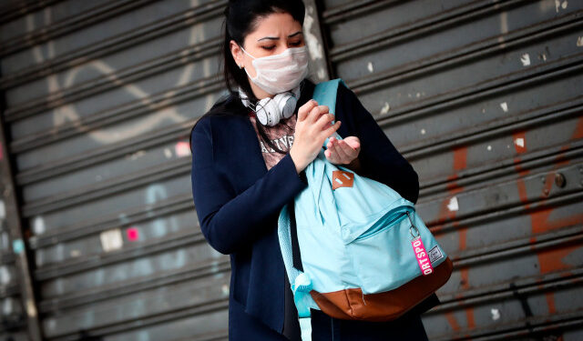 BRA300. SÃO PAULO (BRASIL), 24/04/2020.- Una mujer usa gel antibacterial mientras camina por una calle este viernes, en Sao Paulo (Brasil). Sao Paulo, epicentro de la pandemia en Brasil, cumple este viernes un mes en cuarentena y ya ha comenzado a planificar la reapertura "gradual" de su economía a partir del 11 de mayo, pese a que las muertes y contagios aceleran y el país todavía no ha alcanzado el pico. EFE/ Fernando Bizerra Jr.