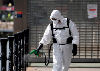 London (United Kingdom), 31/03/2020.- A cleaner sprays disinfectant outside the Emirates Air Line office in Central London, Britain, 31 March 2020. According to news reports, the NHS is anticipating a Coronavirus 'tsunami' as the peak of infection rates nears. British Prime Minister Boris Johnson has announced that Britons can only leave their homes for essential reasons or may be fined, in order to reduce the spread of the Coronavirus. (Reino Unido, Londres) EFE/EPA/WILL OLIVER