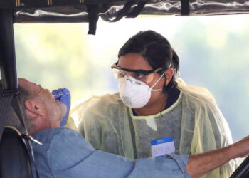 A resident of The Villages, Fla. gets tested for the coronavirus with a nasal swab at a drive-through site that accomodates golf carts, at The Villages Polo Club, Monday, March 23, 2020. The testing site is being operated by UF Health, with University of Florida medical students performing the tests. (Joe Burbank/Orlando Sentinel/Tribune News Service via Getty Images)