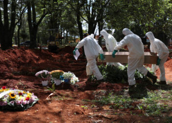 Gravediggers wearing protective suits carry the coffin of someone who died suspected to have had coronavirus disease (COVID-19), at Vila Formosa cemetery, Brazil's biggest cemetery, in Sao Paulo, Brazil, April 2, 2020. REUTERS/Amanda Perobelli