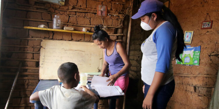 A teacher visits student at home after the closing of schools during the nationwide quarantine due to coronavirus disease (COVID-19) outbreak in El Pao, Venezuela April 1, 2020. Picture taken April 1, 2020. REUTERS/William Urdaneta NO RESALES NO ARCHIVE