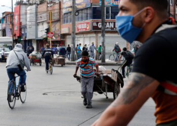 AME6043. BOGOTÁ (COLOMBIA), 27/04/2020.- Trabajadores y ciudadanos se aglomeran este lunes en las calles luego de concederse un decreto que permite, entre otras cosas, el regreso a las labores para el sector de la construcción durante la pandemia de la COVID-19, en Bogotá (Colombia). Miles de trabajadores colombianos de los sectores de la construcción y las manufacturas empezaron a volver este lunes a sus labores en una confusa jornada debido a la oposición de algunos alcaldes a la controvertida flexibilización de la cuarentena por el coronavirus autorizada por el Gobierno de Iván Duque. EFE/ Mauricio Dueñas Castañeda