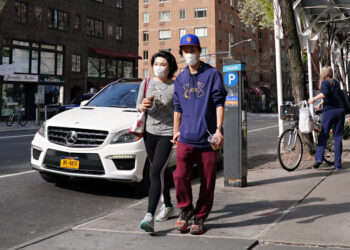 NEW YORK, NEW YORK - APRIL 07: A couple walk while wearing protective masks during the coronavirus pandemic on April 07, 2020 in New York City. COVID-19 has spread to most countries around the world, claiming almost 70,000 lives with infections nearing 1.3 million people.   Cindy Ord/Getty Images/AFP
