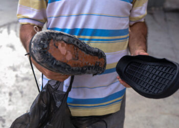 ACOMPAÑA CRÓNICA: VENEZUELA CRISIS - CAR04. CARACAS (VENEZUELA), 06/10/2018.- Fotografía del 27 de Septiembre de 2018, de un hombre que muestras las suelas de repuesto para un par de zapatos, en Caracas (Venezuela). Miles de venezolanos caminan por las calles de Caracas con los zapatos rotos o desgastados; una imagen que hace juego con el agrietado y viejo asfalto de las calles de Venezuela, donde cada calzado deteriorado es la cruda expresión de la crisis del país con las mayores reservas petroleras del mundo. Ellos se enfrentan a la difícil situación de no tener cómo comprar ni siquiera un par de zapatos de baja calidad, cuyos precios oscilan hoy entre los 700 y 3.000 bolívares (11 y 48 dólares, según la tasa oficial). EFE/Cristian Hernández