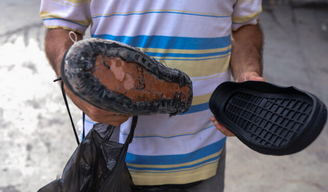ACOMPAÑA CRÓNICA: VENEZUELA CRISIS - CAR04. CARACAS (VENEZUELA), 06/10/2018.- Fotografía del 27 de Septiembre de 2018, de un hombre que muestras las suelas de repuesto para un par de zapatos, en Caracas (Venezuela). Miles de venezolanos caminan por las calles de Caracas con los zapatos rotos o desgastados; una imagen que hace juego con el agrietado y viejo asfalto de las calles de Venezuela, donde cada calzado deteriorado es la cruda expresión de la crisis del país con las mayores reservas petroleras del mundo. Ellos se enfrentan a la difícil situación de no tener cómo comprar ni siquiera un par de zapatos de baja calidad, cuyos precios oscilan hoy entre los 700 y 3.000 bolívares (11 y 48 dólares, según la tasa oficial). EFE/Cristian Hernández