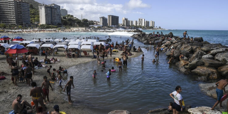 People enjoy Camurichico beach in La Guaira, Vargas state, Venezuela, on January 12, 2020. - With rum, reggaeton and "no change" on the horizon, Venezuelans go to the beach after a week of protests and disputes in the National Assembly. (Photo by Yuri CORTEZ / AFP)