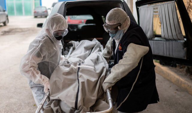 Mortuary workers move the body of a COVID-19 victim at a crematorium in Cuautitlan Izcalli, Mexico State, on April 23, 2020. - By Wednesday, Mexico had registered 10,500 coronavirus cases and just under 1,000 deaths. (Photo by PEDRO PARDO / AFP)