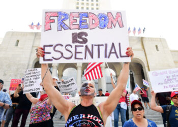 Demonstrators rally in front of Los Angeles City Hall on May 1, 2020, to demand the end to the state's shutdown due to the coronavirus pandemic. (Photo by Frederic J. BROWN / AFP)