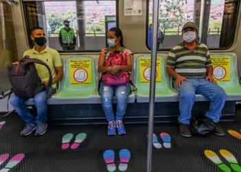 People wear face masks and sit on designated seats on a metro car as a preventive measure against the spread of the novel coronavirus COVID-19, in Medellin, Colombia, on May 4, 2020. - The novel coronavirus has killed at least 249,372 people worldwide since the outbreak first emerged in China last December, according to a tally from official sources compiled by AFP at 1900 GMT on Monday. (Photo by JOAQUIN SARMIENTO / AFP)