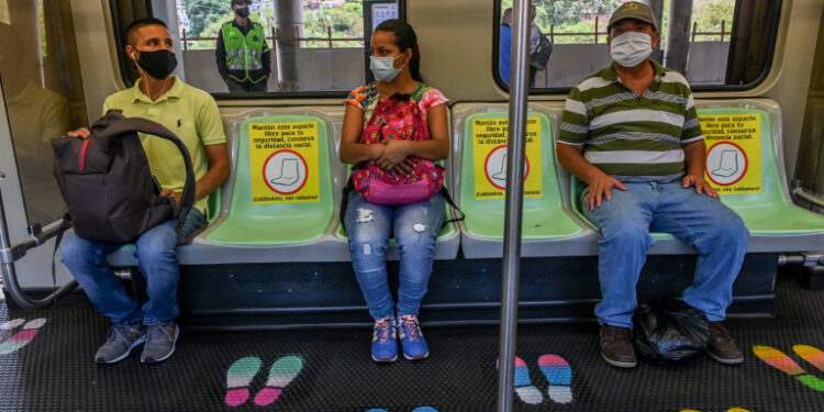 People wear face masks and sit on designated seats on a metro car as a preventive measure against the spread of the novel coronavirus COVID-19, in Medellin, Colombia, on May 4, 2020. - The novel coronavirus has killed at least 249,372 people worldwide since the outbreak first emerged in China last December, according to a tally from official sources compiled by AFP at 1900 GMT on Monday. (Photo by JOAQUIN SARMIENTO / AFP)