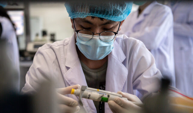 A worker is seen inside the Beijing Applied Biological Technologies (XABT) research and development laboratory in Beijing on May 14, 2020. - XABT is a Chinese company specializing in developing pathogens diagnostics, among them reagent kits for the COVID-19 coronavirus. (Photo by NICOLAS ASFOURI / AFP)