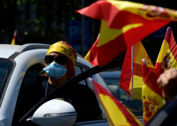A protester honks from her car as she takes part in a "caravan for Spain and its freedom" protest by far-right party Vox against the government at the Plaza de Colon in Madrid on May 23, 2020. - Spain, one of the most affected countries in the world by the novel coronavirus with 28,628 fatalities, has extended until June 6 the state of emergency which significantly limits the freedom of movement to fight the epidemic. The left-wing government's management of the crisis has drawn a barrage of criticism from righ-wing parties who have denounced its "brutal confinement". (Photo by JAVIER SORIANO / AFP)