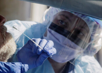 Nurse Theresa Malijan administers a test for coronavirus disease (COVID-19) to a patient at a drive-through testing site in a parking lot at the University of Washington's Northwest Outpatient Medical Center, during the coronavirus disease (COVID-19) outbreak, in Seattle, Washington, U.S. March 18, 2020.  REUTERS/David Ryder